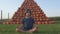 A child in the process of meditating in nature. A mountain of orange pumpkins.