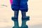 Child in a puddle of water wearing welly boots
