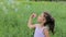 Child puff soap bubbles. Girl inflate soap bubbles. Little curly girl blowing soap bubbles