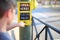 Child pushes the traffic light button to cross the road, where it says in Spanish: Wait for green and Pedestrian press