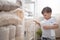 The child puts the bedding in a closet with neatly folded things. vertical storage.