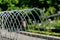 Child putting his finger into the sprinkling water of a fountain with detailed water drops