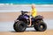 Child on quad bike at beach. All-terrain vehicle.