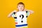 Child with question mark. Curious child over yellow background. Schoolboy shows question mark. Cute little boy asking question