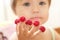Child with raspberry on fingers, focus on hands