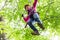 Child reaching platform climbing in high rope course