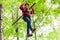 Child reaching platform climbing in high rope course