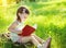 Child reading a book on the grass in sunny summer