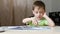 A child reads a book while sitting at the table at home