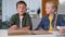 child reads book using his hands at home, blind boy learns while sitting with his sister with plaster cast on arm