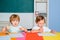 Child is ready to answer with a blackboard on a background. Kid school. Child from elementary school with book and bag