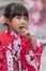 Child in red kimono looking pensive Asakusa