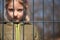 Child refugee behind a metal fence