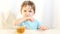 The child refuses to drink tea from a glass cup. The child is not happy and does not want to drink a drink.