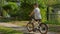 Child rides bicycle in summer weather with toy multi-colored windmill. shooting from behind, slow motion video. Child
