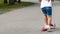 Child riding scooter. Happy little kid girl playing pink kick board on road in park outdoors on summer day, Active children games