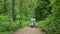 Child riding a toy car in the forest park