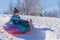 Child is riding tubing winter game.