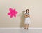 Child with roller brush near color wall.