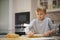 Child  rolling dough with a rolling pin, close up view. Boy rolls out the dough on the kitchen table