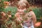 Child with rose flower in spring garden