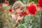 Child with rose flower in spring garden