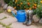 Child Rubber Boots And Watering Can In Garden.