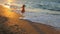 Child running along the surf