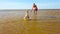 Child running to his mother through the water on the beach