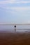 Child Runs on Beach Alone. Massive beach with small child. Vertical.