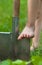 Child`s bare foot on the metal spade