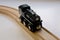 Child\'s black wooden toy train on wood tracks