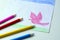 A child\'s drawing of a pink dove, grass and sky with colored pencils