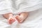 Child& x27;s feet and legs peeking, wrapped in purity. Concept of infant& x27;s delicate bath moments