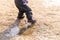 Child`s feet in rubber boots stained in spring mud