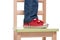 Child\'s feet standing on the little chair