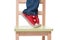 Child\'s feet standing on the little chair on tiptoes