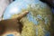 Child`s finger indicating a place on the globe