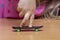 Child`s fingers on a fingerboard, wooden surface, close-up, selective focus. Fingerskate finger training.