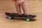 The child`s fingers ride on a fingerboard, wooden surface, close-up. Fingerskate finger training.