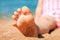 Child\'s foot is close to the sandy beach