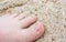 Child`s foot in the sand