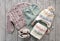 Child`s girl knitwear set on wooden background flat lay. Kid`s winter woolen clothes top view. Toddler knitted cardigan,pants,ha
