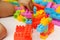 Child`s hand building plastic toy blocks with blurred background.