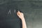 Child`s hand with chalk write alphabet on black chalkboard