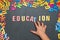 Child`s hand laid out the word education from multicolored plastic letters