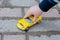 The child`s hand leads a yellow toy car photo horizontal, close-up. The idea is children`s play, development