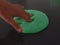 Child`s hand poking bright green slime