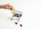 A child& x27;s hand pushes a metal supermarket trolley with multicolored numbers. Concept: back to school