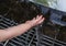 Child`s hand touching the flow of water